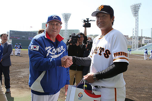 한국 WBC 대표팀의 김인식 감독(왼쪽)과 요미우리의 다카하시 요시노부 감독이 19일 일본 오키나와 나하 셀룰러스타디움에서 열린 연습경기에 앞서 기념품을 주고 받고 악수를 하고 있다. 사진제공 | KBO