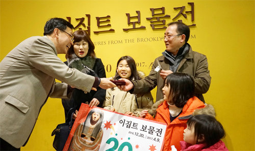 19일 서울 용산구 국립중앙박물관에서 열리고 있는 이집트전에 20만 번째로 입장한 이호우 씨 가족이 금으로 만든 행운의 열쇠를 받고 있다. 국립중앙박물관 제공