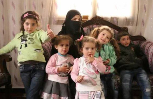 시리아 감옥의 인권유린 실태를 폭로한 라샤 샤르바지 씨가 지난주 반군 점령지인 알레포의 자택에서 다섯 자녀와 함께 사진을 찍고 
있다. 감옥에서 낳아 보육원으로 보내진 쌍둥이 딸은 아직까지 엄마를 알아보지 못하고 있다. 텔레그래프 제공