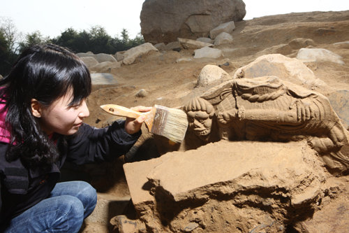 한 발굴조사원이 목탑터에서 녹유신장벽전을 노출시키고 있다. 국립경주문화재연구소