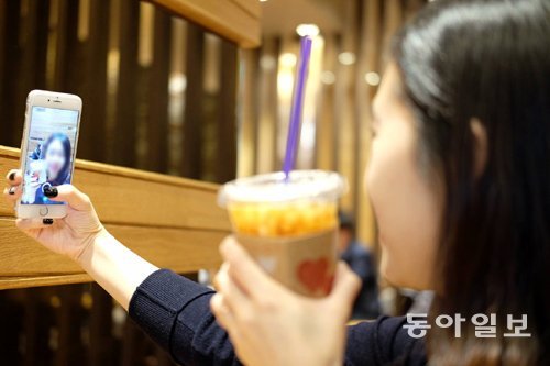 한 여성이 조명 좋은 여의도의 어느 카페에서 커피를 소품으로 셀카를 찍고 있다. 염지현 기자 ginny@donga.com