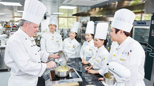 우송정보대는 세계적인 제과·제빵 교육기관인 프랑스 INBP의 교육프로그램을 올 1학기부터 전격적으로 도입해 세계적인 제과·제빵 명장 배출을 꿈꾸게 됐다. 사진은 외국인 교수로부터 실습을 받고 있는 우송정보대 글로벌제과제빵과 학생들. 우송정보대 제공