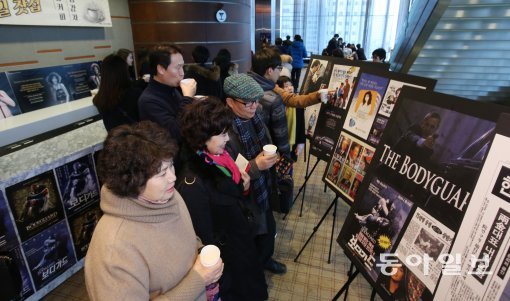 뮤지컬 ‘보디가드’가 공연되는 서울 강남구 역삼동 LG아트센터에 원작 영화가 개봉됐던 1992년 분위기를 연출하는 ‘1일찻집’이 마련됐다. 관람객들이 공연 전 황영조 선수의 1992년 8월 바르셀로나 올림픽 금메달 쾌거를 알리는 동아일보 지면과 단성사에서 개봉된 영화 포스터 등을 보며 추억에 잠기고 있다.신원건 기자 laputa@donga.com