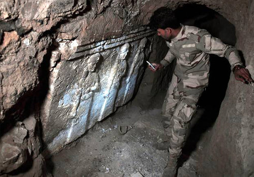 이라크 군인이 최근 이슬람국가(IS)의 모술 동부 지하 땅굴에서 발견한 고대 아시리아 제국 석상을 휴대전화 불빛으로 비추고 있다. 기원전 7∼8세기 것으로 추정된다. CNN 제공
