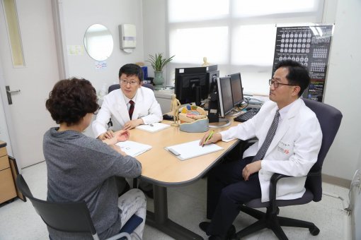 뇌질환 환자에게 신경과 의사(오른쪽)와 한방신경정신과 교수가 협진하는 장면. 동국대병원 제공