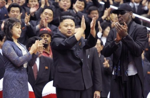 김정은이 북한을 방문한 미국 프로농구 스타 데니스 로드먼과 함께 묘기 농구단 할렘 글로브트로터스와 북한팀의 친선경기를 보며 박수를 치고 있다. 오른쪽은 김정은의 부인 이설주.