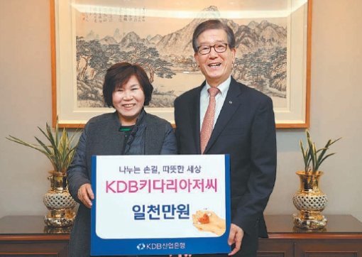 KDB산업은행은 27일 서울 영등포구 은행로 본점에서 ‘KDB 키다리 아저씨’ 8번째 나눔 행사를 열고 무료 공부방 ‘키다리교실’에 1000만 원을 전달했다. 강명희 키다리교실 원장(왼쪽)과 이동걸 산은 회장. KDB산업은행 제공