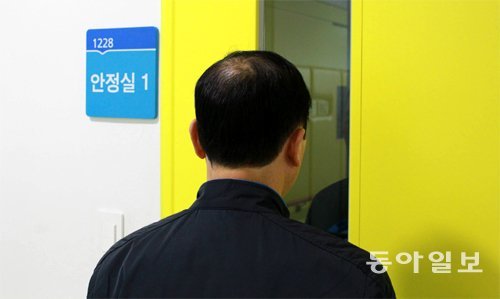 지난달 20일 우울증이 급격히 악화돼 국립정신건강센터 ‘마음 응급실’에서 안정제를 맞고 잠든 아들을 A 씨(55)가 창문 너머로 바라보고 있다. 봄엔 기후가 빠르게 변해 A 씨의 아들처럼 평소 우울증을 앓던 환자가 호르몬 변화에 따른 증상 악화를 호소하는 일이 잦다. 조건희 기자 becom@donga.com