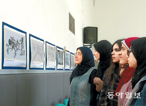 이집트 여대생들이 8일 카이로 한국학교에서 열린 북한 인권 실태 전시회에서 수감자들의 참상을 그린 작품을 진지한 표정으로 바라보고 있다. 카이로=조동주 특파원 djc@donga.com