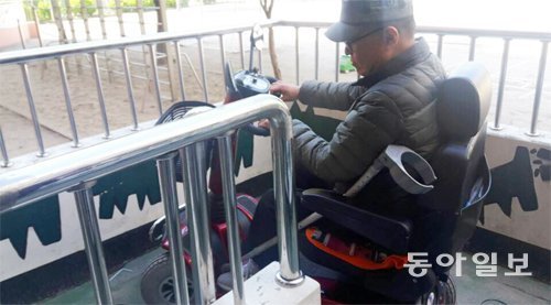 장애인의 날을 하루 앞둔 19일 서울 광진구의 대선 투표소를 점검하던 유진환 씨가 휠체어를 타고 좁은 경사로를 오르며 어려움을 겪고 있다. 김예윤 기자 yeah@donga.com