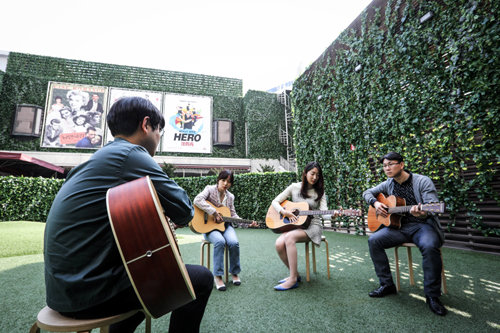 7일 오후 서울 종로구 낙원악기상가 4층 야외 공연장에서 시민들이 기타 강습을 받고 있다. 뒤편에 옛 허리우드극장이 보인다. 지금은 고전 명작 영화를 상영하는 ‘실버영화관’과 ‘낭만극장’, 논버벌 퍼포먼스 ‘페인터즈 히어로’ 공연장으로 쓰인다. 안웅철 사진작가 제공