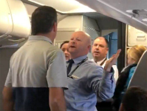 21일 미국 샌프란시스코발 아메리칸항공 여객기 안에서 남성 승무원(오른쪽)이 여성 승객의 유모차를 거칠게 빼앗아 분노를 사고 
있다. 이에 분노한 한 남성 승객(왼쪽)이 자리에서 일어나 이 승무원과 말싸움을 벌이고 있다. 사진 출처 승객 수라인 아디안타야 씨
 페이스북