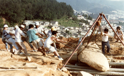 1980년 복천동 고분 발굴현장에서 작업자들이 3t 무게의 무덤 덮개돌을 도르래로 들어올리고 있다. 부산대박물관 제공