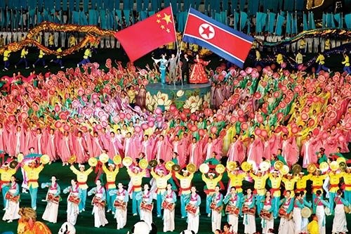 북한 무용수들이 아리랑 공연에서 인공기와 오성홍기를 들고 북·중 친선을 강조하고 있다.[ 위키피디아]