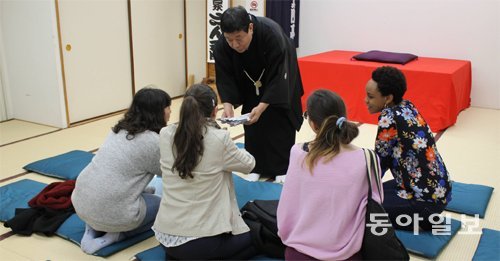 지난달 27일 유명 만담가인 야나기야 산쿄 씨(가운데 서 있는 사람)가 일본 도쿄에서 외국인 대상 만담회를 마친 후 관객과 대화를 나누고 있다. 도쿄=장원재 특파원 peacechaos@donga.com