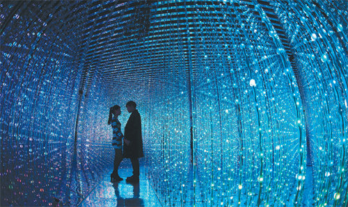 서울 송파구 잠실동에 있는 디지털 미디어 아트 상설 전시장 ‘팀랩월드’를 찾은 관객들이 ‘크리스털 유니버스(Crystal Universe)’를 관람하며 한 드라마의 남녀 주인공 모습을 연출하고 있다. “빛의 조각(점)의 집합체를 통해 우주 공간을 표현한 쌍방향 설치미술”이라는 것이 작가의 설명. 관객의 움직임에 따라 영롱한 조명들이 오로라처럼 움직인다.