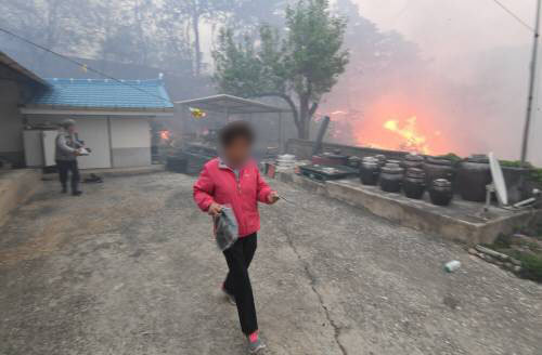 6일 오후 3시 27분께 강릉시 성산면에서 발생한 산불이 확산해 집을 위협하자 주민이 황급히 대피하고 있다. (강원일보제공)