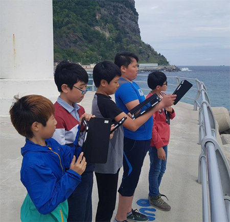 경북 울릉군 남양초등학교 학생들이 10일 학교 인근에서 삼성전자 스마트스쿨이 제공하는 태블릿PC를 활용해 독도 정보를 찾아보고 있다. 남양초등학교 제공