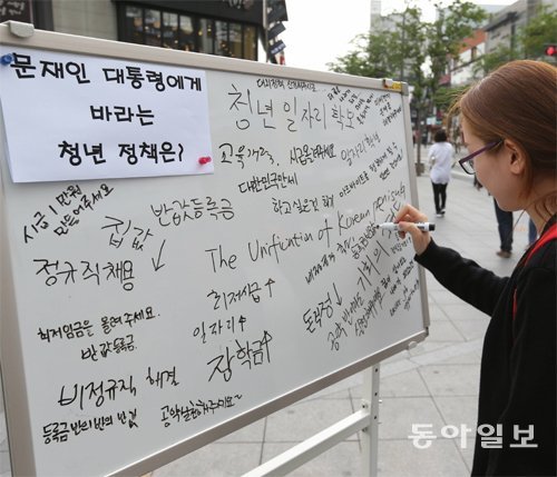 대통령에게 바라는 청년 정책은… 10일 오전 서울 서대문구 신촌 대학가에 설치한 청년 보드에 한 
여학생이 ‘등록금 반값’이라는 문구를 적고 있다. 이날 특별취재팀은 ‘문재인 대통령에게 바라는 청년 정책은?’ ‘공공일자리 81만
 개 창출에 대한 나의 생각은?’ 등의 물음을 청년들에게 던졌다. 홍진환 기자 jean@donga.com