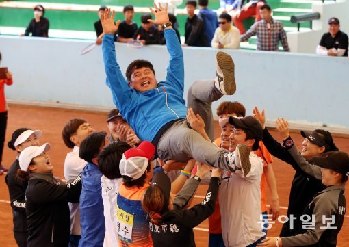 13일 경북 문경시 국제정구장에서 열린 “제95회 동아일보 정구대회 ”단체전 결승에서 문경시청선수들이 여자팀 김희수코치를 행가레치며 기뻐하고 있다. 문경=김경제 기자 kjk5873@donga.com