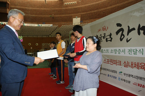 김병곤 스포원 이사장(왼쪽)이 23일 스포원 실내체육관에서 열린 소망리퀘스트 수여식에서 장애인들에게 소망증서를 수여하고 있다. 스포원 제공