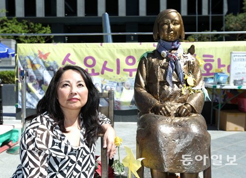 한국계 미국 소설가 노라 옥자 켈러 씨가 25일 주한 일본대사관 앞 평화의 소녀상 앞에 앉았다. 그는 2015년 한일 위안부 합의를 “정치적인 이유로 힘없는 여성의 목소리를 묻어버리려는 것”이라고 비판했다. 변영욱 기자 cut@donga.com
