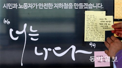 28일 오전, 1년 전 이날 ‘구의역 스크린도어 사고’가 벌어진 서울 광진구 지하철 2호선 구의역 사고현장 스크린도어에 시민이 추모 내용을 담은 포스트잇을 붙이고 있다. 원대연 기자 yeon72@donga.com