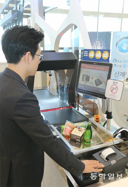서울 송파구 롯데월드타워의 세븐일레븐 무인 편의점에서 김성모 기자가 핸드 페이(손바닥 정맥 결제)로 간식을 사고 있다. 변영욱 기자 cut@donga.com