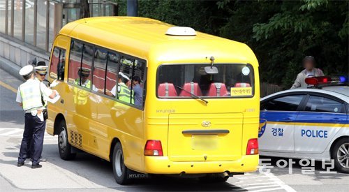 경찰이 서울 강남구의 한 초등학교 앞에서 통학차량 안전 상태를 점검하는 모습. 변영욱 기자 cut@donga.com