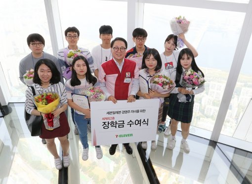 정승인 세븐일레븐 대표(가운데)와 경영주 자녀들이 학자금 수여식 후 기념 촬영을 하고 있다. 사진제공 l 세븐일레븐