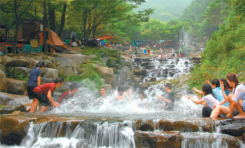 대구 달성군 비슬산 자연휴양림 계곡에서 관광객들이 물놀이를 하며 더위를 식히고 있다. 달성군 제공