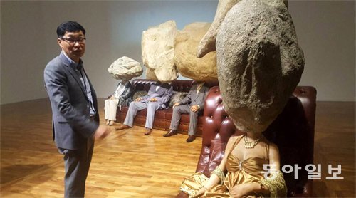 이상봉 시립미술관장이 ‘헬로우 시티’ 전에 소개된 중국 쑨위안과 펑위의 ‘소년소녀’에 대해 설명하고 있다. 이 작품은 번듯한 차림의 사람들의 머리를 바위로 표현함으로써 삶의 고뇌와 무게를 드러내고자 했다. 지명훈 기자 mhjee@donga.com