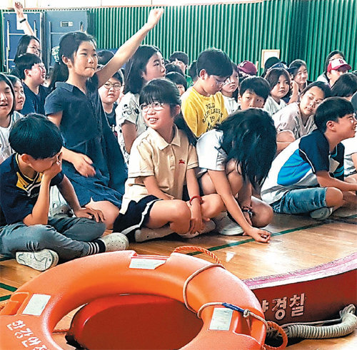 20일 서울 동작구 흑석초등학교 강당에서 열린 인천해경의 ‘찾아가는 연안 안전교실’에서 5학년생들이 경찰관의 질문에 대답하려고 손을 들고 있다. 인천해양경비안전서 제공