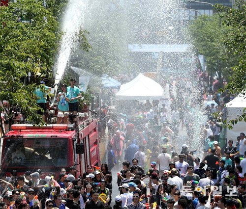 지난해 7월 서울 서대문구 연세로에서 열린 ‘제4회 신촌물총축제’에서 시민들이 물총놀이를 즐기는 동안 소방차에서 뿜어낸 물줄기가 쏟아지고 있다. 동아일보DB