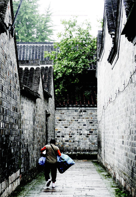 한 여성이 중국 난징에 있는 전통 건물 사잇길을 걷고있다. 높은 담이 폐쇄적으로 느껴진다. 스윙밴드 제공