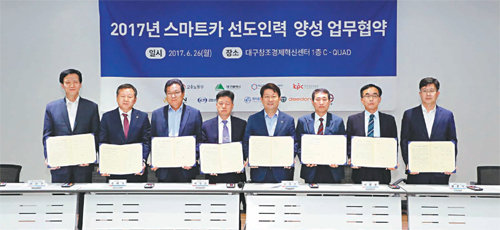 26일 대구창조경제혁신센터에서 이춘우 한국생산성본부 상무와 소순구 제인모터스 부사장, 권태경 대동공업 이사, 차달준 경창산업 사장, 권영진 대구시장, 이원찬 아진산업 이사, 임종덕 평화홀딩스 상무, 연규황 대구창조경제혁신센터장(왼쪽부터)이 스마트카 선도인력 양성 업무 협약을 체결하고 있다. 대구시 제공