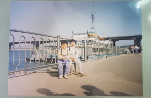 <사진1. 스마트폰 카메라로 사진을 촬영한 모습. 좌우로 여백이 남고, 빛이 반사(오른쪽 상단)되어 이미지의 일부분이 유실된다>(출처=IT동아)