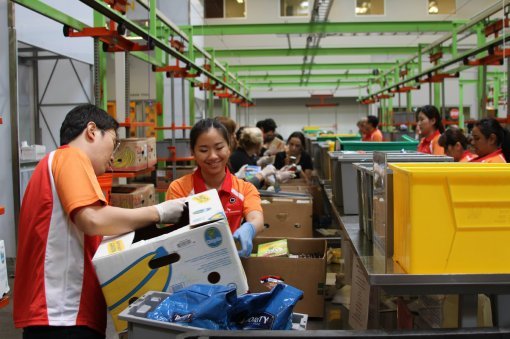 SK이노베이션 석유개발 사업본부 직원들이 지난달 미국 휴스턴 외곽에 있는 한 푸드뱅크에서 음식을 담은 상자를 정리하는 봉사활동을 하고 있다. SK제공