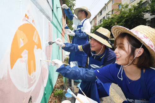 전영현 삼성SDI 사장(가운데)이 지난달 30일 경기 수원시 산남초등학교에서 직원들과 함께 벽화그리기 봉사활동을 하고 있다. 삼성SDI 제공