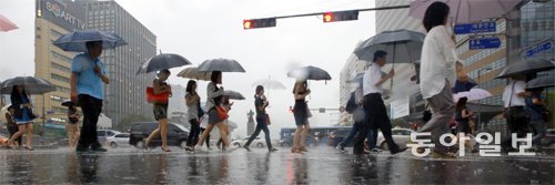 장마가 본격적으로 시작된 가운데 시민들이 비 오는 서울 종로구 광화문 거리에서 우산을 쓴 채 걷고 있다. 전문가들은 장마철 건강 유지를 위해 외출 후 젖은 몸을 깨끗이 씻고 말리고 실내 온도를 지나치게 낮추지 않을 것을 권했다. 동아일보DB