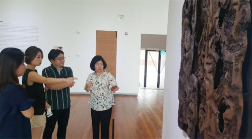 4일 대전 이응노미술관에서 개막한 ‘스위스로 간 이응노’ 전. 이지호 관장(오른쪽)이 학예사들과 함께 벽에 걸린 나무 부조 ‘무제’를 보며 이야기를 나누고 있다.