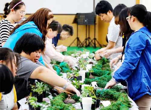 전남 나주 화탑마을은 마을회와 영농조합법인이 힘을 합쳐 수익사업과 복지사업을 공동으로 꾸려 가고 있다. 원예체험에 참가한 젊은이들이 모종을 심고 있다. 화탑마을 제공