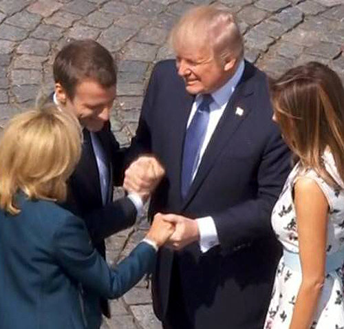 도널드 트럼프 미국 대통령(왼쪽에서 세 번째)이 14일 프랑스 파리 바스티유 광장에서 오른손으로 에마뉘엘 마크롱 프랑스 대통령의 손을, 왼손으론 브리지트 마크롱 여사의 손을 잡고 있다. NBC 방송 화면 캡처