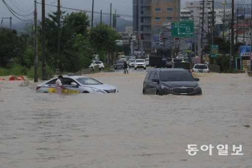 사진=16일 충북 청주시에 내린 갑작스런 폭우로 미호천인근 도로가 범람하여 청주시 흥덕구 탑연삼거리에 차량이 침수되어 있다. 박영철 기자 skyblue@donga.com