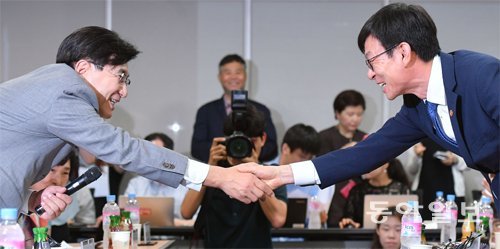 웃으며 악수했지만… 김상조 공정거래위원장(오른쪽)과 박기영 한국프랜차이즈산업협회장이 28일 서울 중구 대한상공회의소에서 열린 간담회서 악수하고 있다. 원대연 기자 yeon72@donga.com