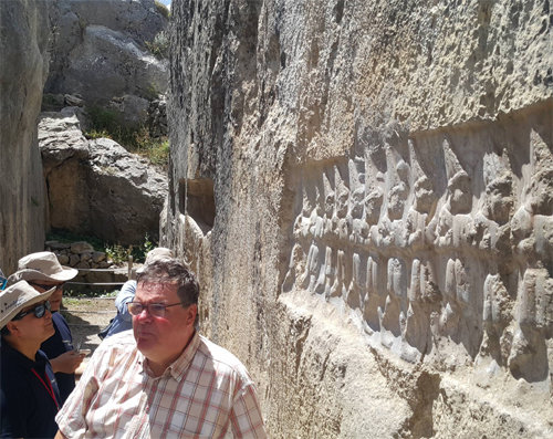지난달 23일 터키 초룸주 하투샤 야즐르카야 유적에서 안드레아스 샤흐너 발굴단장이 군인 12명을 돌에 새긴 부조를 설명하고 있다. 그의 등 뒤로 왕의 시신을 안치한 벽감과 또 다른 부조가 보인다.
