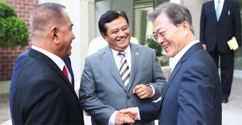 여름휴가 중인 문재인 대통령(오른쪽)이 2일 경남 창원시 진해의 해군기지에서 랴미자르드 랴쿠두 인도네시아 국방장관(왼쪽), 우마르 하디 주한 인도네시아대사와 반갑게 인사를 나누고 있다. 청와대 제공