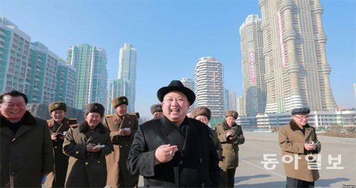 올해 1월 완공을 앞두고 평양 여명거리를 돌아보는 김정은. 그 뒤에서 웃고 있는 북한 권력자들은 이런 신도시 개발의 최대 수혜자들이기도 하다. 동아일보 DB
