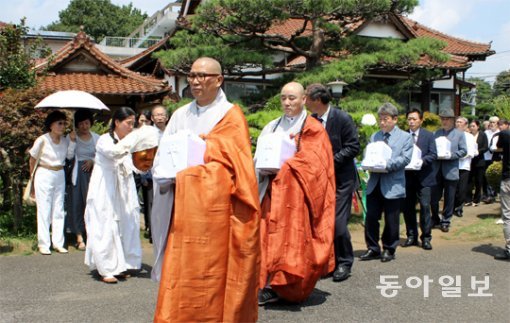 일제 강제징용 희생자 유해봉환위원회 관계자들이 6일 도쿄 소재 재일동포 사찰 국평사에서 강제징용 등으로 일본에 왔다가 세상을 떠난 무연고 유골 33위를 한국으로 가져오기 위해 유골함을 들고 나오고 있다. 도쿄=장원재 특파원 peacechaos@donga.com