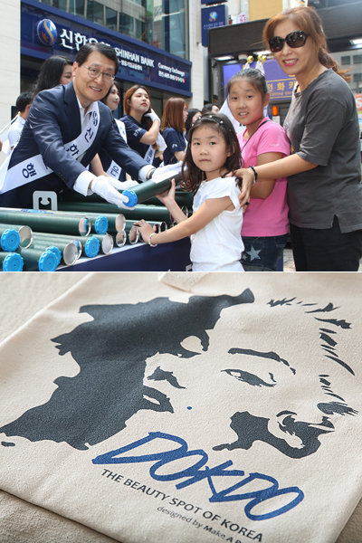 광복절을 맞아 금융·유통업계의 ‘애국마케팅’이 한창이다. 위성호 신한은행장이 ‘나라사랑 태극기사랑’ 캠페인을 통해 서울 명동을 방문한 시민들에게 태극기를 나눠주고 있는 모습(위쪽)과 GS25가 준비한 ‘독도 사랑 에코백’.사진제공 l 신한은행·GS25